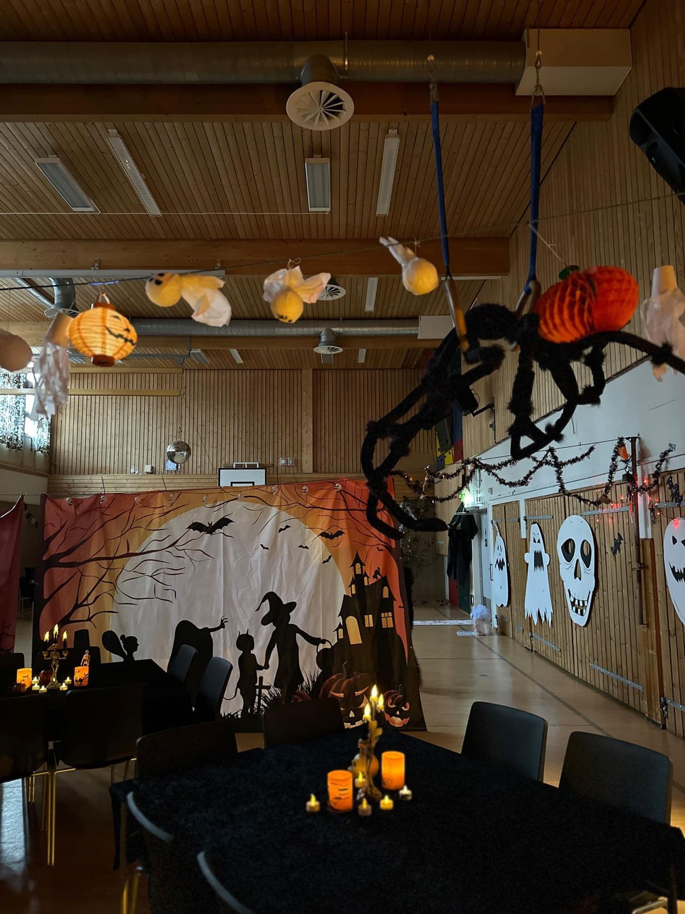 et rom med bord og stoler og en vegg med lykter fra det