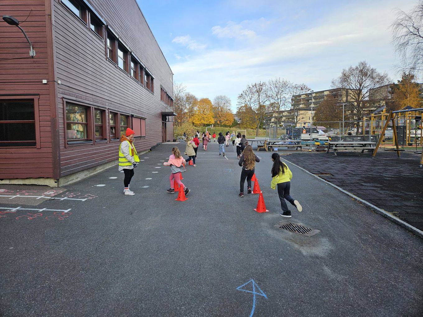 En gruppe mennesker som går på en gate med kjegler
