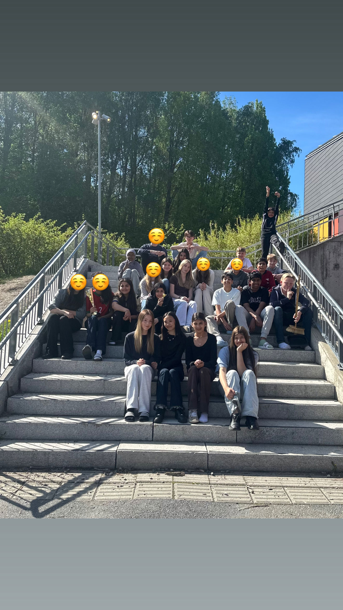 En gruppe mennesker poserer for et bilde på noen trapper